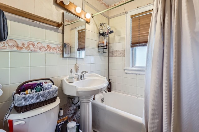 bathroom featuring shower / bath combination with curtain, toilet, and tile walls