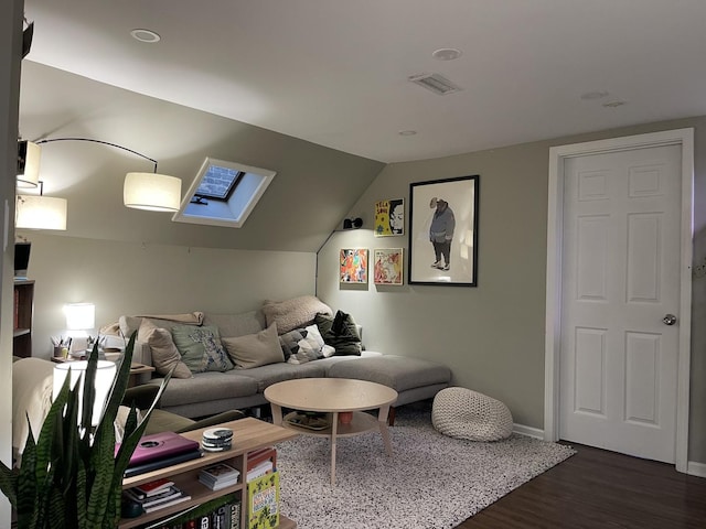 living room with dark wood-type flooring and vaulted ceiling with skylight