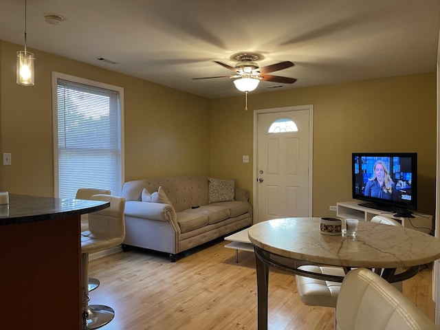 living room with ceiling fan and light hardwood / wood-style flooring