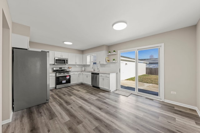 kitchen featuring white cabinetry, light hardwood / wood-style flooring, sink, and appliances with stainless steel finishes