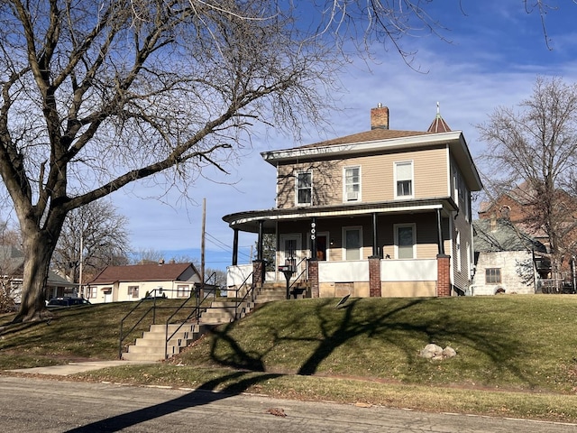 view of front facade featuring covered porch and a front lawn