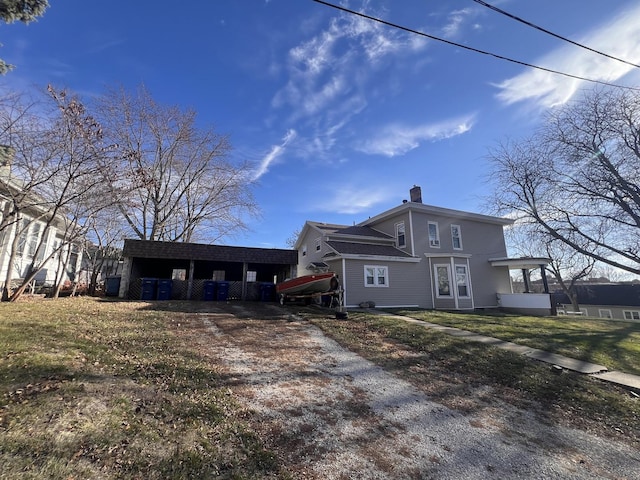 rear view of property featuring a lawn