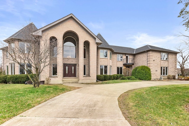 view of front of house with a balcony and a front lawn