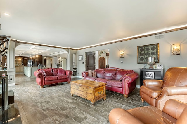 living room with ornamental molding and an inviting chandelier