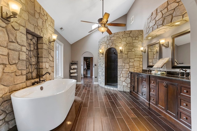 bathroom featuring hardwood / wood-style flooring, ceiling fan, vanity, and high vaulted ceiling