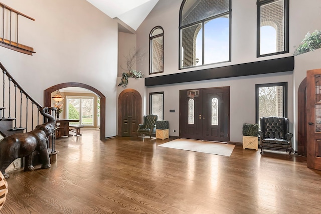 foyer entrance featuring hardwood / wood-style floors and high vaulted ceiling