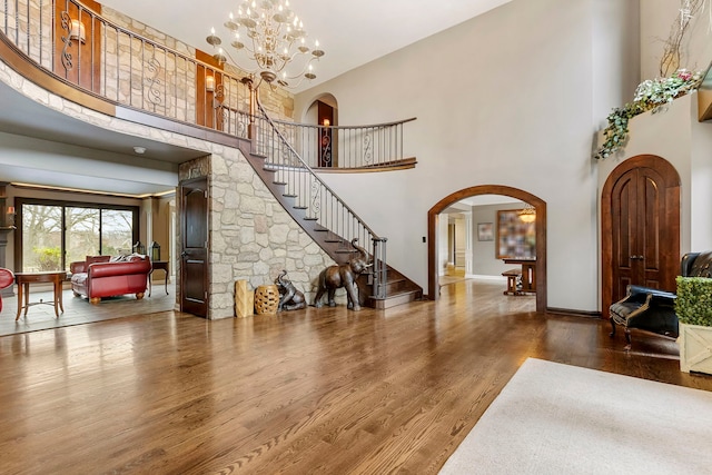 5N259 Wilton Croft Rd, Saint Charles, IL 60175 - living area with a high ceiling, arched walkways, wood finished floors, stairs, and a chandelier