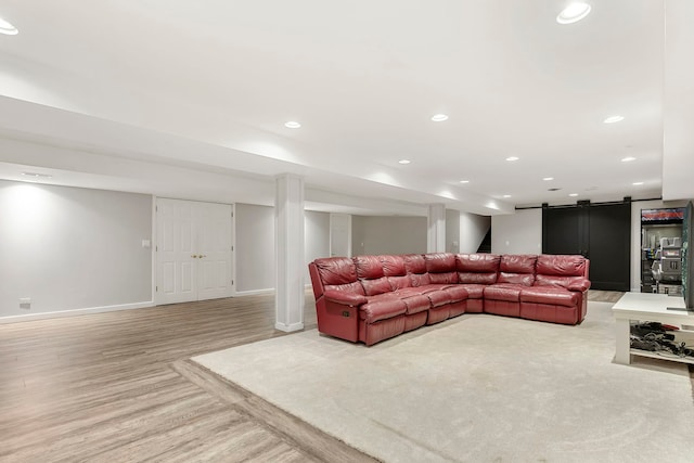 living room with a barn door and light hardwood / wood-style floors