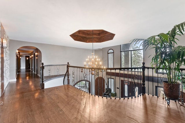 hallway featuring dark hardwood / wood-style flooring and an inviting chandelier