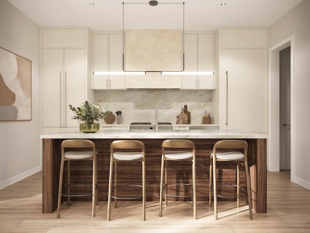 kitchen with a kitchen bar, white cabinetry, light hardwood / wood-style flooring, and tasteful backsplash