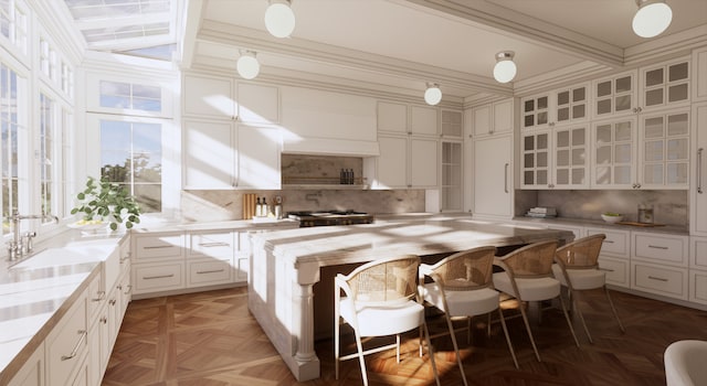 kitchen with a kitchen island, parquet flooring, and white cabinetry