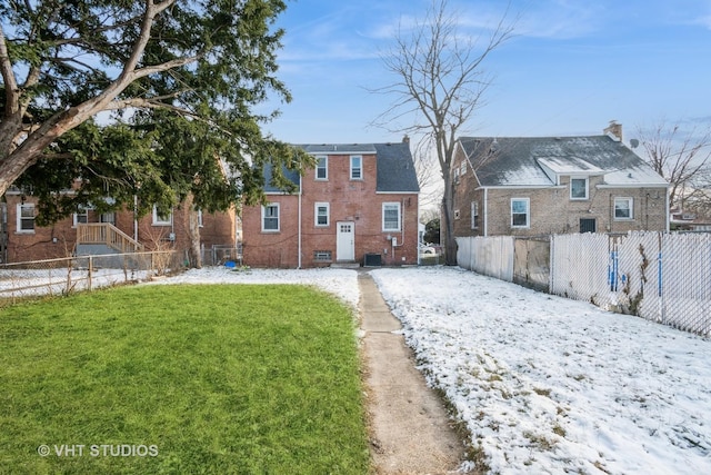 snow covered property with a lawn