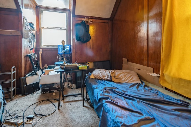 bedroom featuring light carpet and wood walls