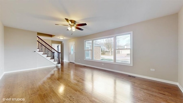 unfurnished living room featuring hardwood / wood-style flooring and ceiling fan