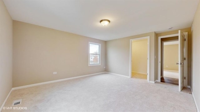 unfurnished bedroom featuring light carpet, a spacious closet, and a closet