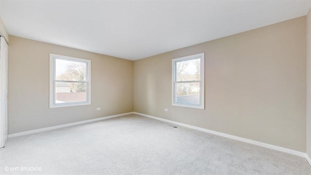 spare room featuring light colored carpet