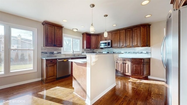 kitchen featuring plenty of natural light, a kitchen island, dark hardwood / wood-style flooring, and stainless steel appliances