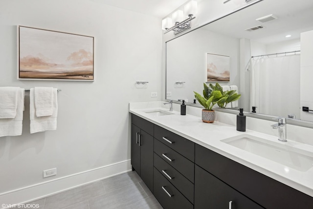 bathroom with double vanity, visible vents, and a sink