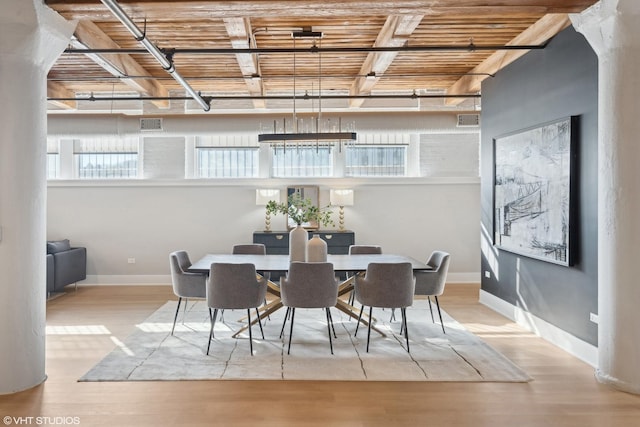 dining space featuring baseboards, visible vents, and light wood finished floors