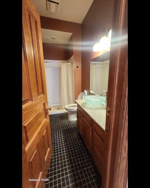 bathroom featuring tile patterned floors, a shower with curtain, vanity, and toilet