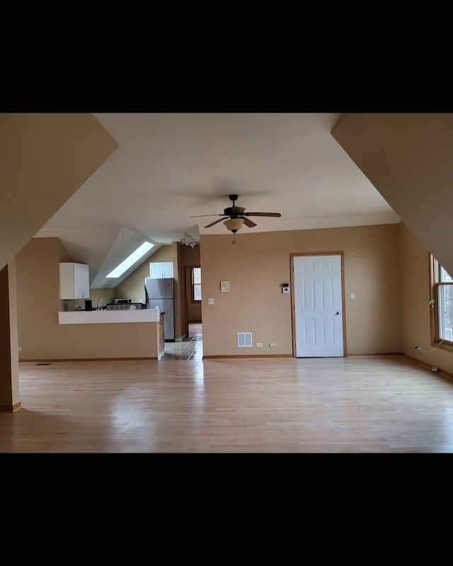 additional living space with light hardwood / wood-style flooring and ceiling fan