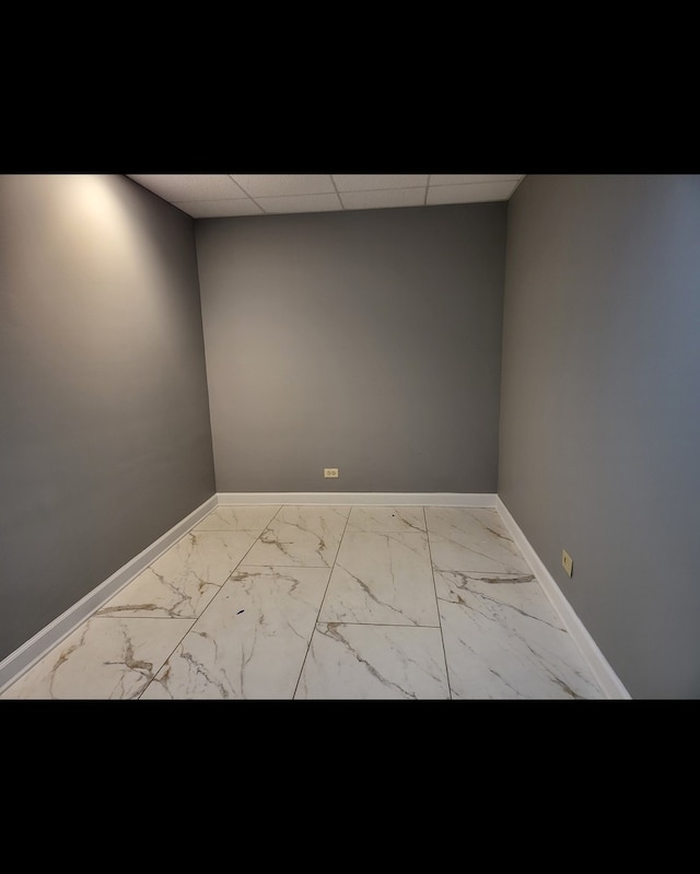 unfurnished room featuring a drop ceiling