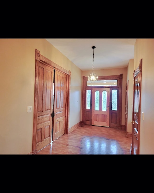 entrance foyer featuring light hardwood / wood-style floors and an inviting chandelier