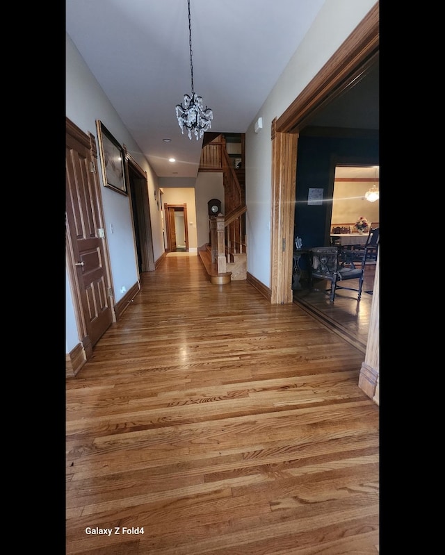 hallway with a notable chandelier and light hardwood / wood-style flooring