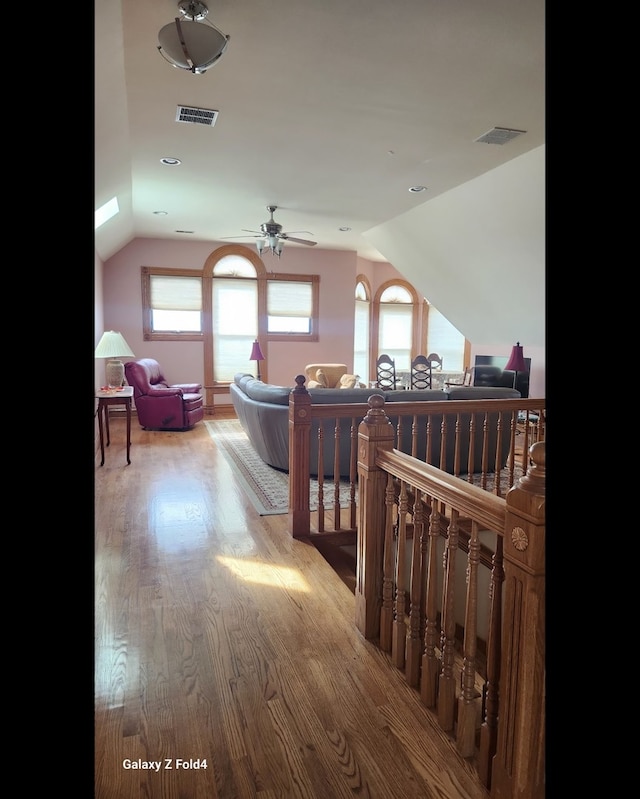 hall with light wood-type flooring and vaulted ceiling