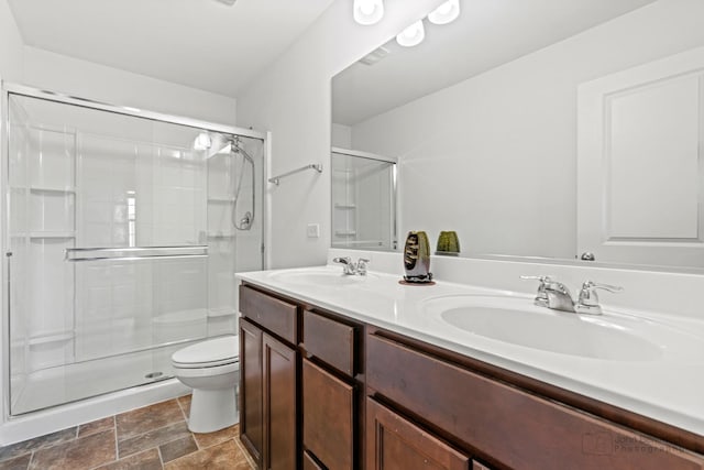 bathroom featuring vanity, toilet, and walk in shower