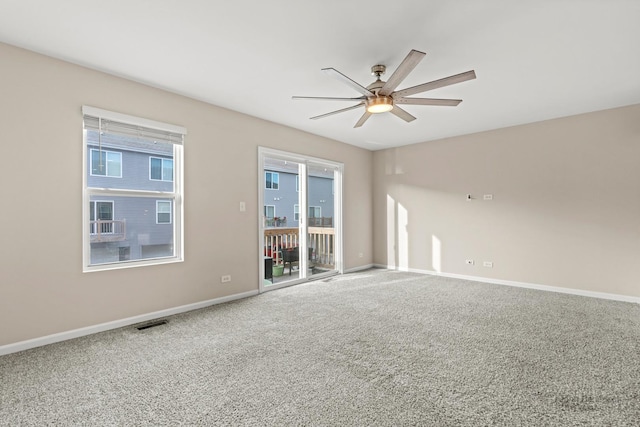 carpeted spare room featuring plenty of natural light and ceiling fan