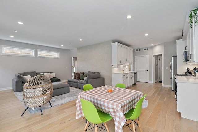 dining area with light hardwood / wood-style flooring and sink