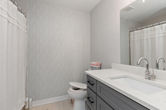 bathroom with vanity, toilet, and wood-type flooring