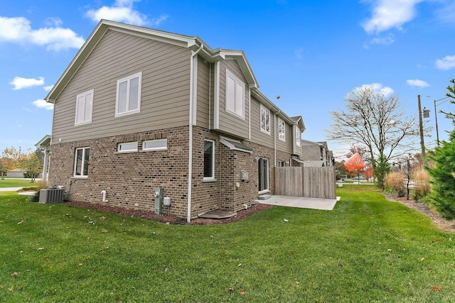 view of side of home featuring central air condition unit, a yard, and a patio