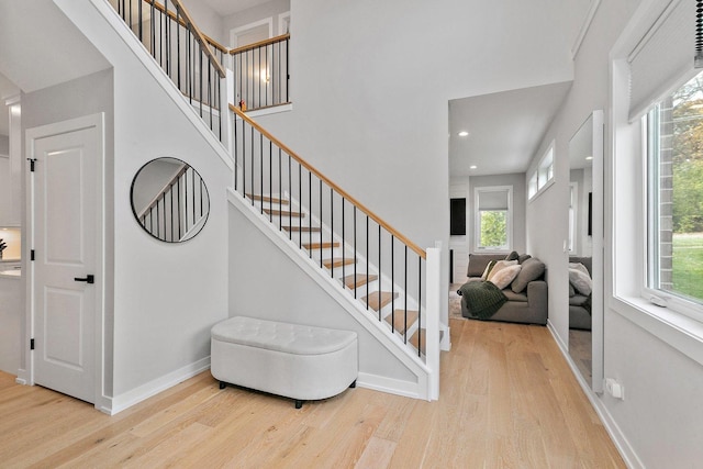 stairs featuring hardwood / wood-style floors and plenty of natural light