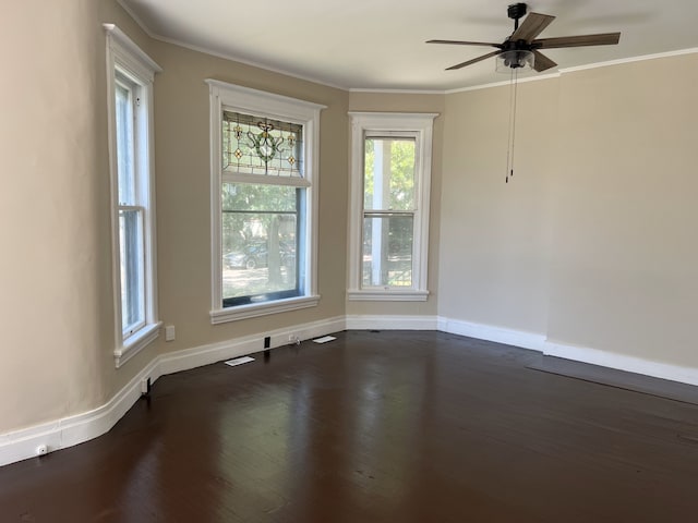 empty room with ceiling fan, dark hardwood / wood-style floors, and ornamental molding