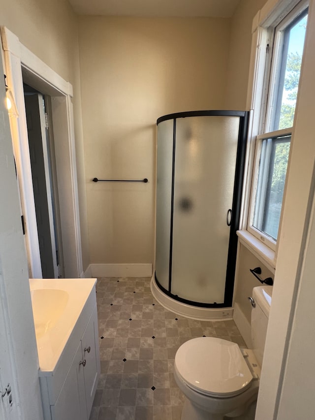 bathroom featuring vanity, toilet, and an enclosed shower