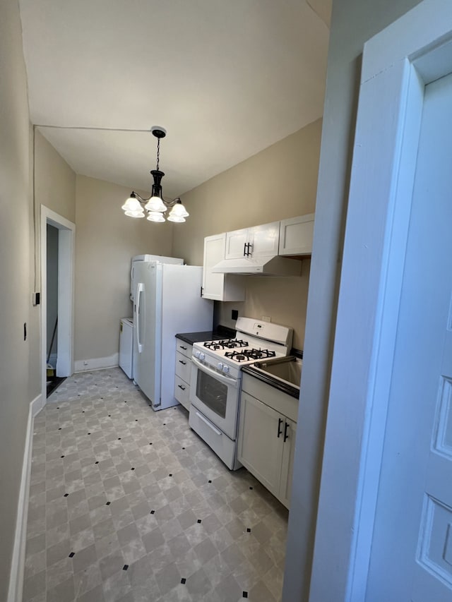 kitchen featuring washing machine and dryer, white cabinets, a chandelier, and white appliances