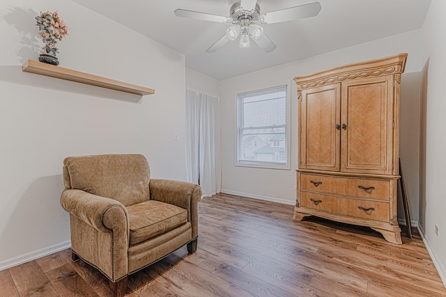 living area with light hardwood / wood-style floors and ceiling fan