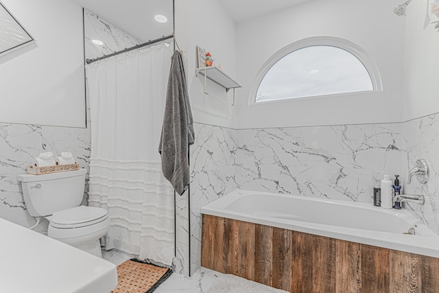 bathroom featuring toilet, tile walls, and a tub