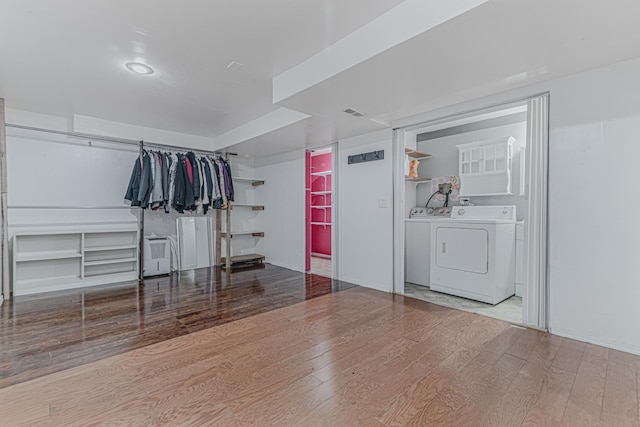 washroom with washing machine and dryer and light hardwood / wood-style flooring