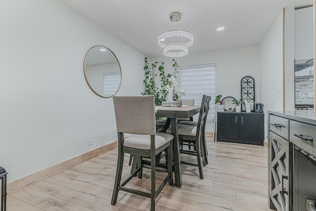 dining space with a chandelier and light hardwood / wood-style floors