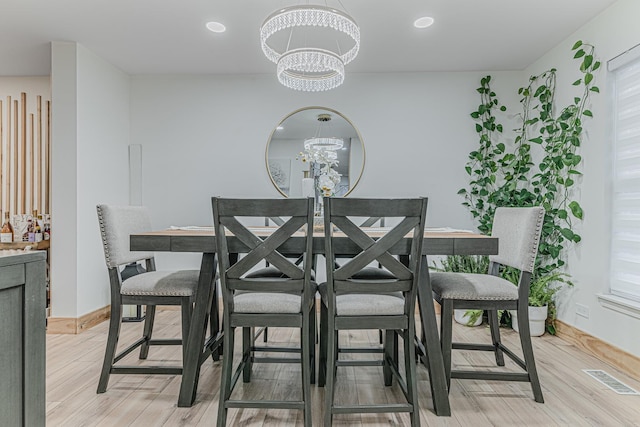 dining room featuring an inviting chandelier and light wood-type flooring