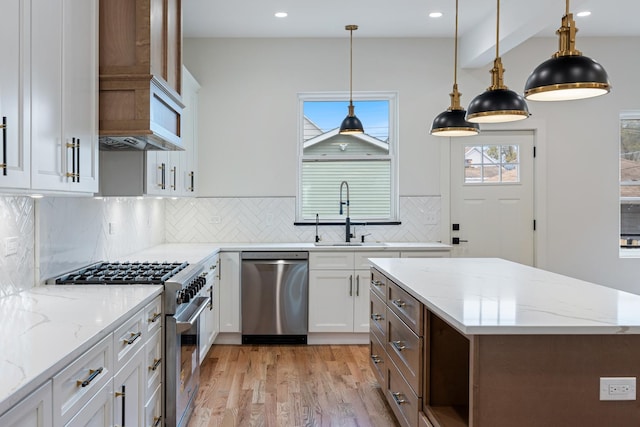 kitchen with white cabinets, light stone counters, sink, and appliances with stainless steel finishes