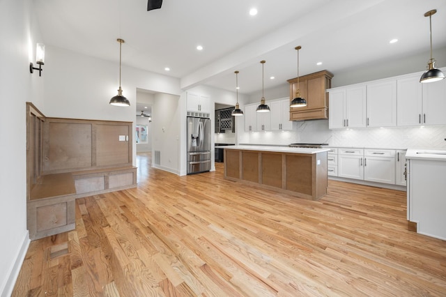 kitchen with pendant lighting, a center island, light wood-type flooring, white cabinetry, and stainless steel appliances