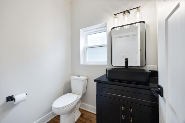 bathroom with hardwood / wood-style floors, vanity, and toilet