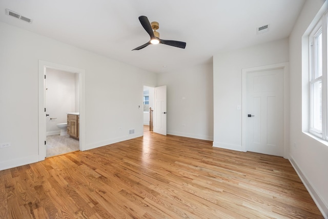 unfurnished bedroom with ceiling fan, a closet, light wood-type flooring, and ensuite bath