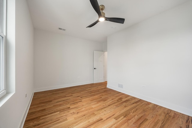 empty room with ceiling fan and light hardwood / wood-style flooring