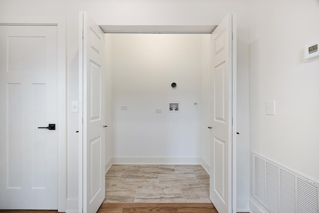 washroom with electric dryer hookup, hardwood / wood-style floors, and washer hookup