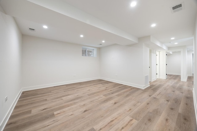 basement with light hardwood / wood-style flooring